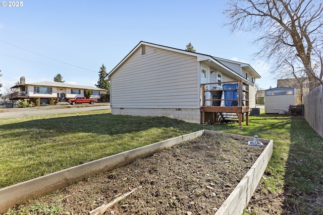 view of property exterior with a vegetable garden, cooling unit, a yard, and fence