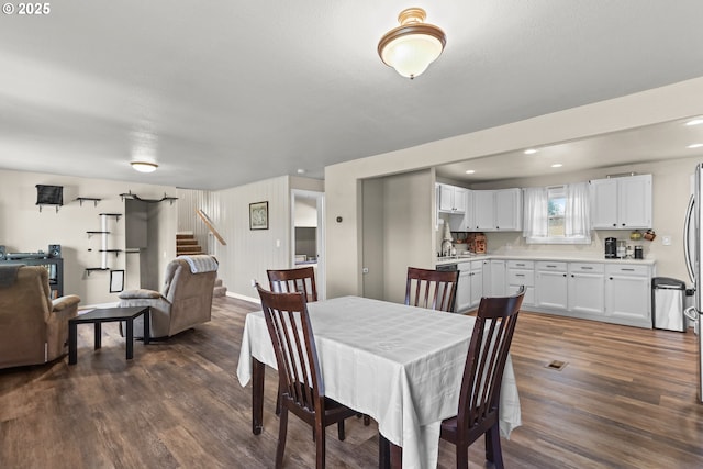 dining area featuring recessed lighting, baseboards, dark wood-type flooring, and stairs