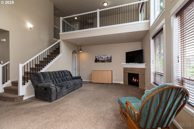 34511 Noble Rd, Saint Helens, OR 97051 - living room featuring stairs, a fireplace, carpet floors, arched walkways, and a high ceiling