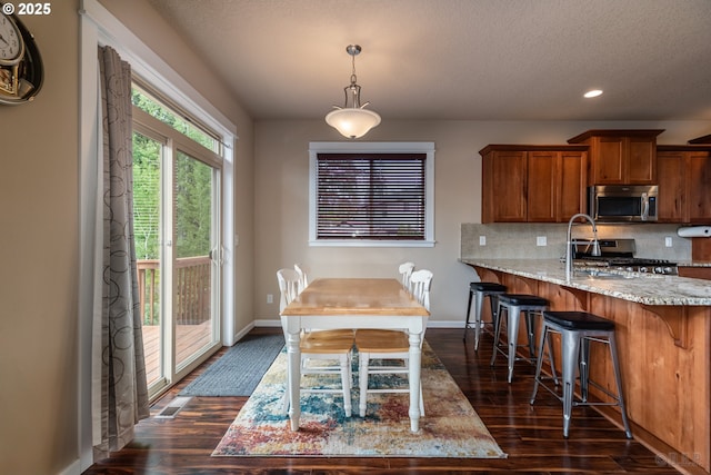 34511 Noble Rd, Saint Helens, OR 97051 - kitchen with range, brown cabinetry, dark wood-style flooring, baseboards, and stainless steel microwave