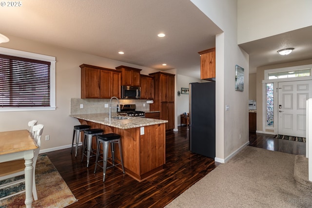 34511 Noble Rd, Saint Helens, OR 97051 - kitchen featuring a sink, a peninsula, brown cabinets, dark wood-type flooring, and appliances with stainless steel finishes