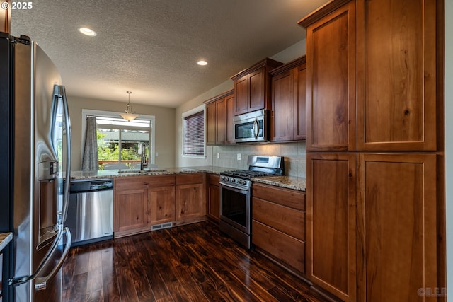 34511 Noble Rd, Saint Helens, OR 97051 - kitchen with stainless steel appliances, dark wood finished floors, a textured ceiling, visible vents, and light stone counters