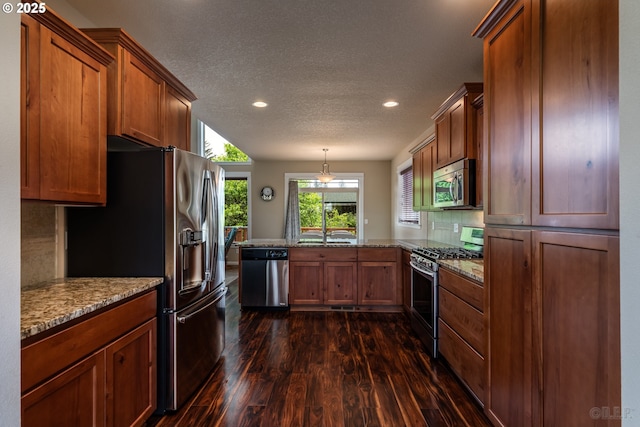 34511 Noble Rd, Saint Helens, OR 97051 - kitchen featuring a peninsula, brown cabinets, dark wood-type flooring, and appliances with stainless steel finishes