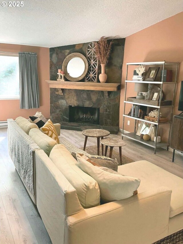 14922 SW 109th Ave, Portland, OR 97224 - living area featuring wood finished floors, a stone fireplace, and a textured ceiling