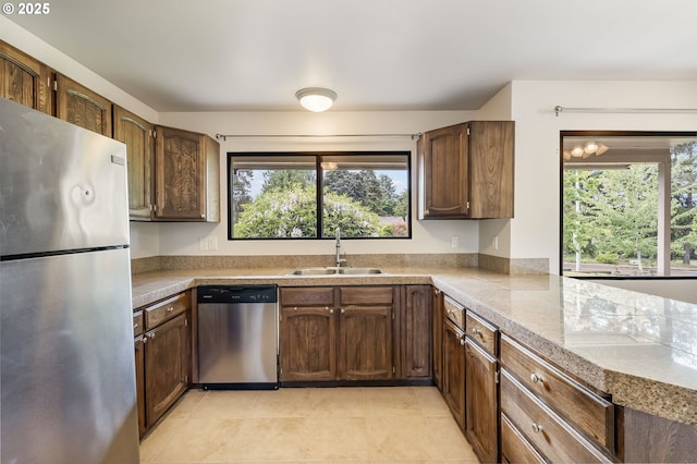 12370 SW 121st Ave, Tigard, OR 97223 - kitchen with stainless steel appliances, a sink, healthy amount of natural light, and light tile patterned floors