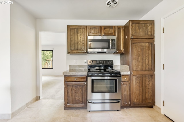 12370 SW 121st Ave, Tigard, OR 97223 - kitchen featuring appliances with stainless steel finishes, light countertops, and baseboards