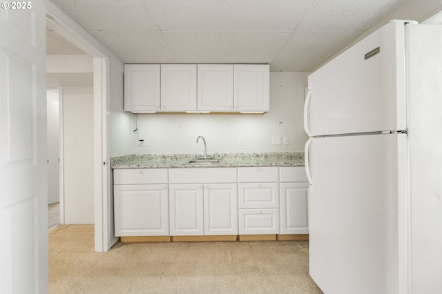 12370 SW 121st Ave, Tigard, OR 97223 - kitchen with freestanding refrigerator, a sink, light carpet, white cabinetry, and a drop ceiling