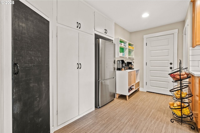 kitchen with white cabinetry and stainless steel fridge