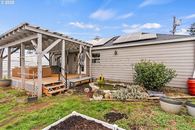 back of house featuring a wooden deck and solar panels