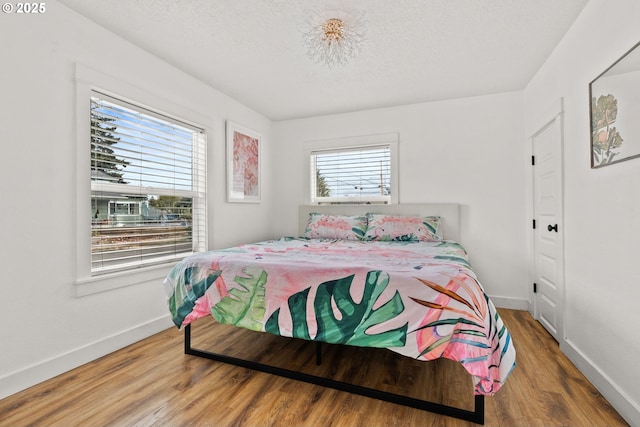 bedroom with hardwood / wood-style flooring and a textured ceiling