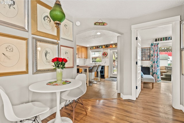 dining space with light hardwood / wood-style flooring and a textured ceiling