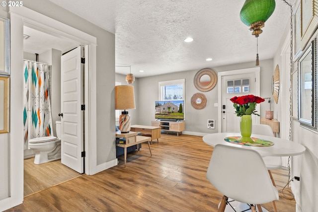 dining area with hardwood / wood-style floors and a textured ceiling