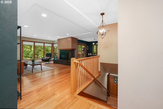 2634 SW Boundary St, Portland, OR 97239 - staircase featuring wood finished floors, a tile fireplace, a chandelier, and recessed lighting