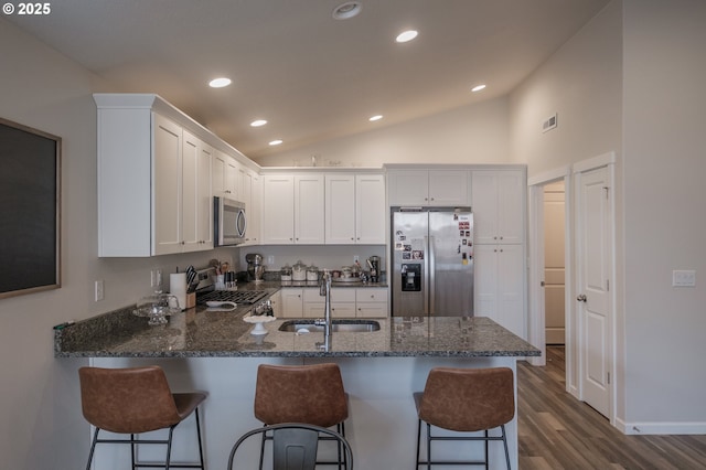 414 SE Ray St, Dallas, OR 97338 - kitchen with appliances with stainless steel finishes, a sink, a peninsula, dark stone countertops, and lofted ceiling
