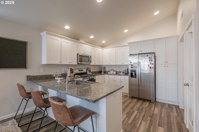 414 SE Ray St, Dallas, OR 97338 - kitchen featuring white cabinets, appliances with stainless steel finishes, dark stone counters, a peninsula, and wood finished floors