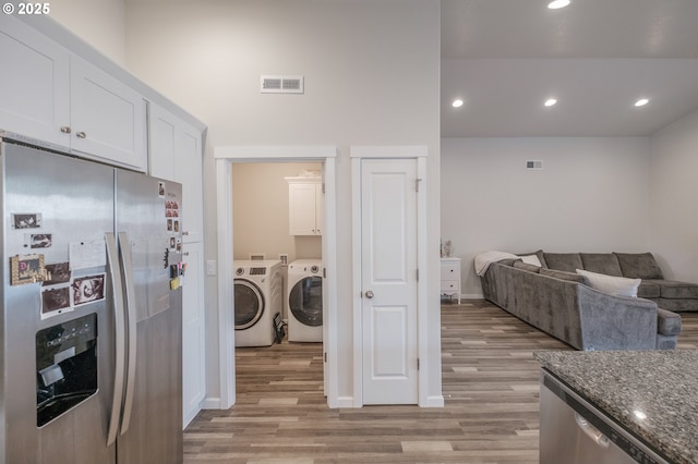 414 SE Ray St, Dallas, OR 97338 - laundry room with light wood-style floors, washing machine and dryer, cabinet space, and visible vents