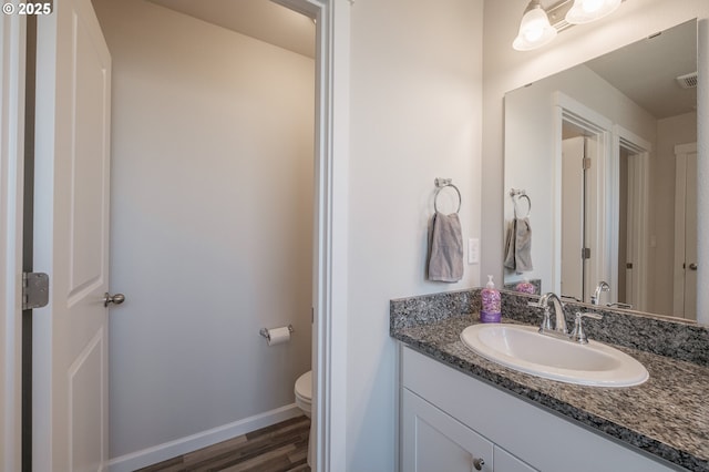 414 SE Ray St, Dallas, OR 97338 - half bath featuring toilet, wood finished floors, vanity, visible vents, and baseboards