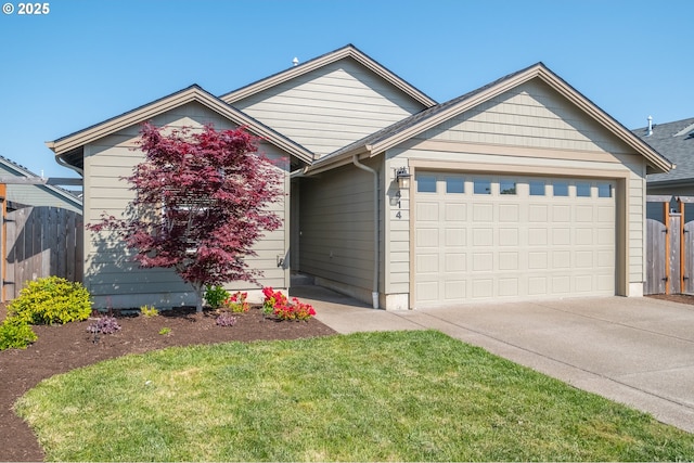 414 SE Ray St, Dallas, OR 97338 - ranch-style home with concrete driveway, fence, a garage, and a front lawn