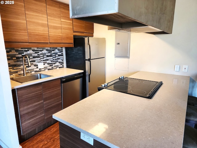 kitchen featuring backsplash, brown cabinetry, a sink, electric panel, and dishwasher