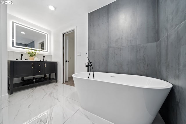 bathroom with a washtub and vanity