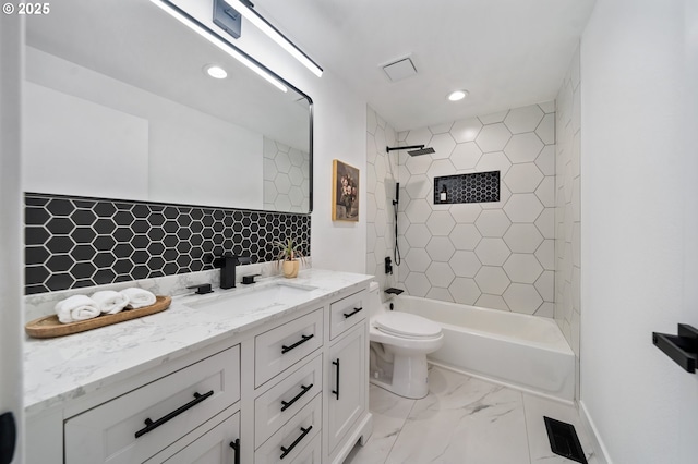 full bathroom with tiled shower / bath, vanity, and toilet