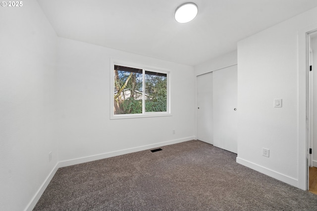 spare room with dark colored carpet