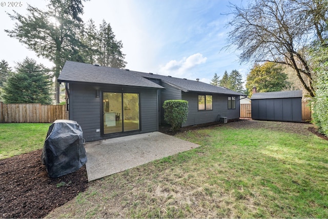 back of house featuring a storage shed, a yard, and a patio area