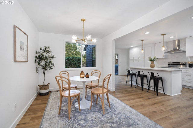 dining area with a chandelier and light wood-type flooring