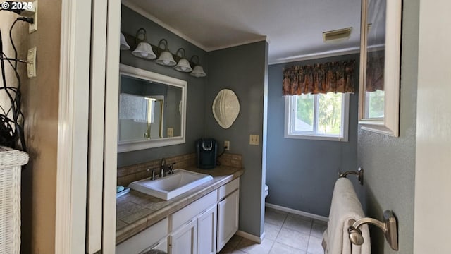 bathroom featuring vanity, tile patterned flooring, ornamental molding, toilet, and baseboards
