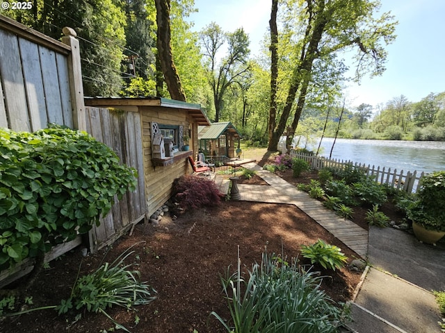 view of yard featuring a water view and fence