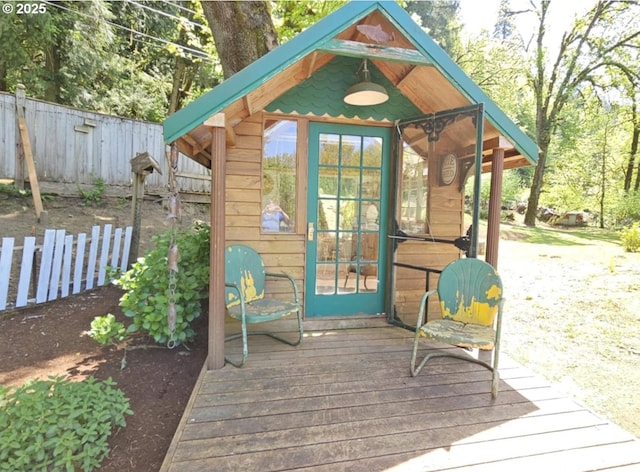 view of outdoor structure featuring fence and an outbuilding