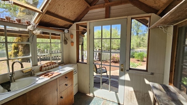 sunroom featuring lofted ceiling and a sink
