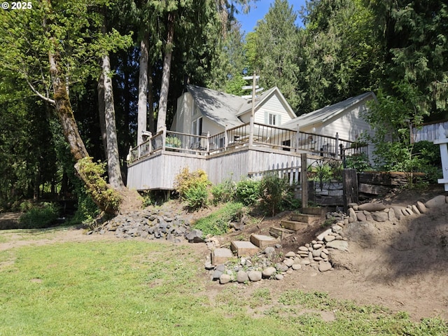 view of home's exterior featuring a deck, stairs, and a lawn