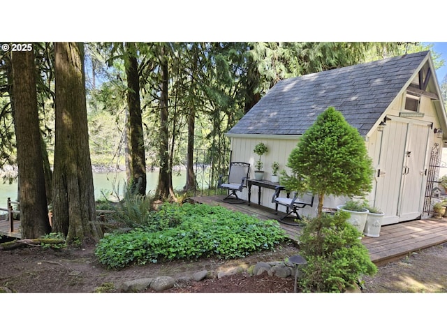 view of yard featuring an outbuilding, a wooden deck, and a storage unit