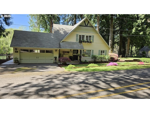 view of front of home featuring a garage, driveway, and a shingled roof