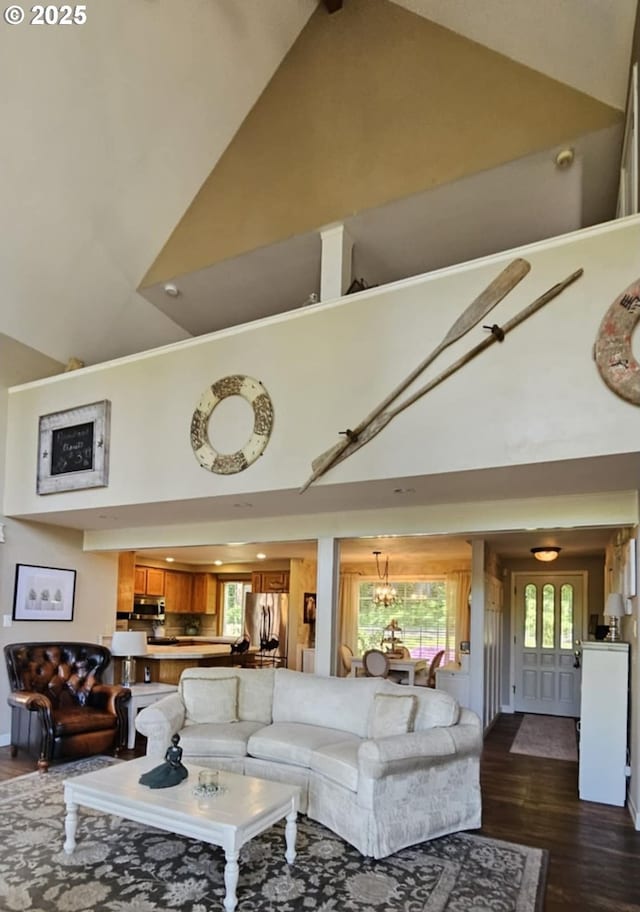 living room with high vaulted ceiling, dark wood-type flooring, and a chandelier