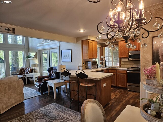 41485 Deerhorn Rd, Springfield, OR 97478 - dining room featuring dark wood finished floors, a chandelier, wallpapered walls, a wainscoted wall, and healthy amount of natural light