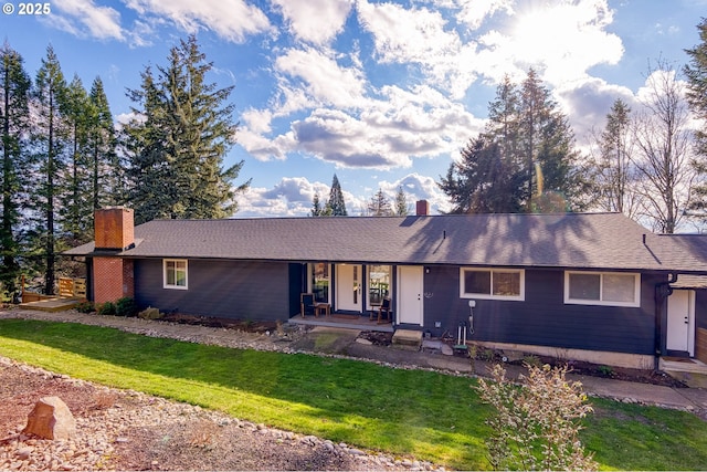 ranch-style home featuring a chimney and a front lawn