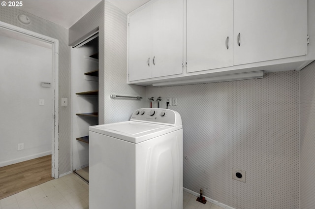 clothes washing area with washer / dryer, cabinet space, baseboards, and light floors