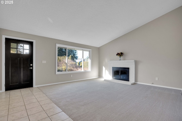 unfurnished living room with vaulted ceiling, plenty of natural light, light colored carpet, and a fireplace