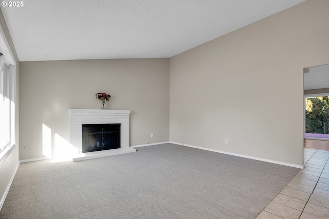 unfurnished living room featuring a fireplace, a textured ceiling, and light tile patterned floors