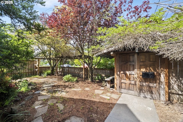 fenced backyard with an outdoor structure and a storage unit