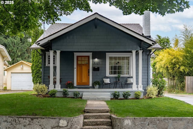 3321 NE 13th Ave, Portland, OR 97212 - view of front of home with covered porch, an outbuilding, a chimney, a front yard, and a garage