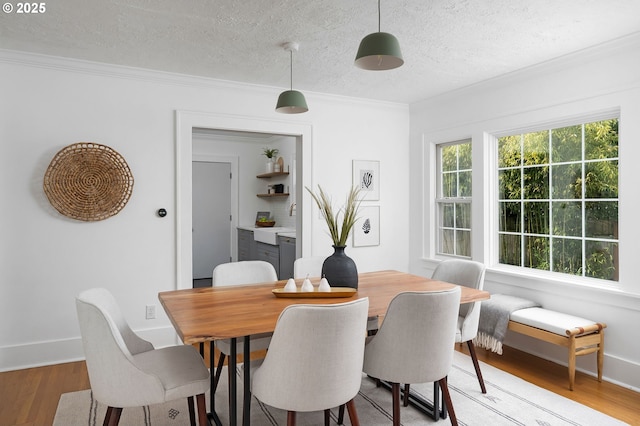 3321 NE 13th Ave, Portland, OR 97212 - dining room with light wood-style floors, a textured ceiling, crown molding, and baseboards