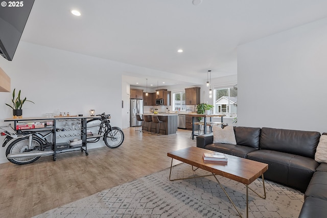 living area with light wood-type flooring and recessed lighting