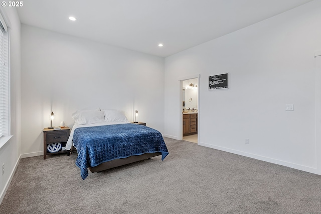 bedroom with recessed lighting, light carpet, baseboards, and ensuite bathroom