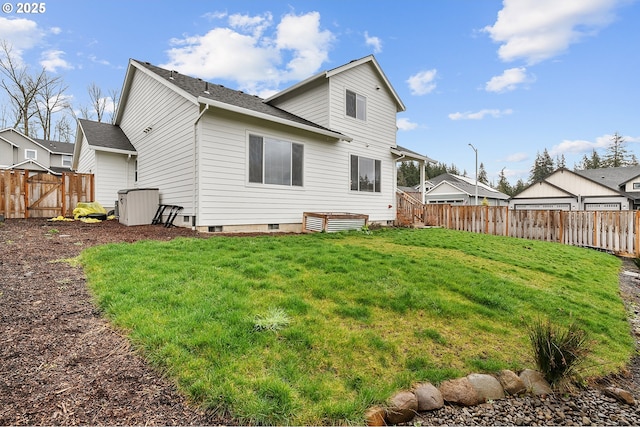 rear view of house with a lawn and fence