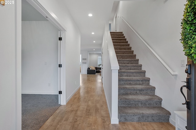 foyer featuring recessed lighting, baseboards, light wood finished floors, and stairs