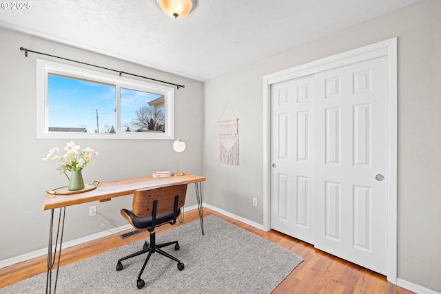 office space featuring visible vents, baseboards, and light wood-style floors