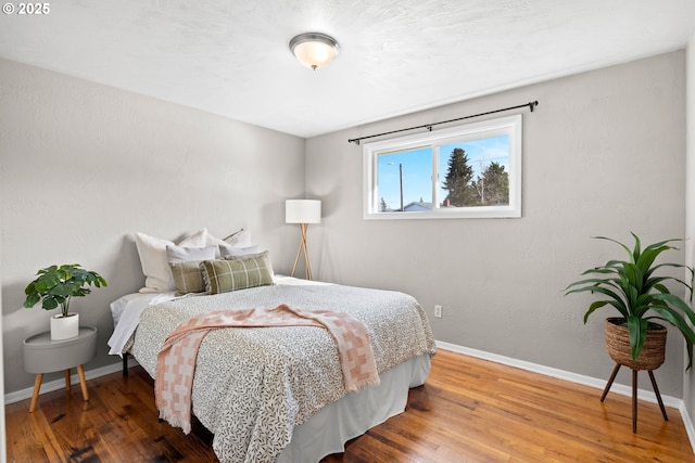 bedroom with baseboards and wood finished floors